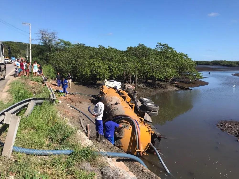 Caminhão limpa-fossas tomba e cai em rio de Natal-RN